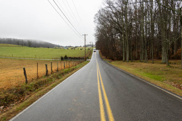 istock Country road with farm in background 1364072546