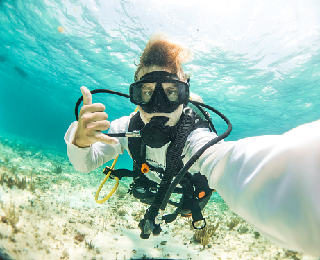 young dive instructor taking a selfie in the caribbean ocean