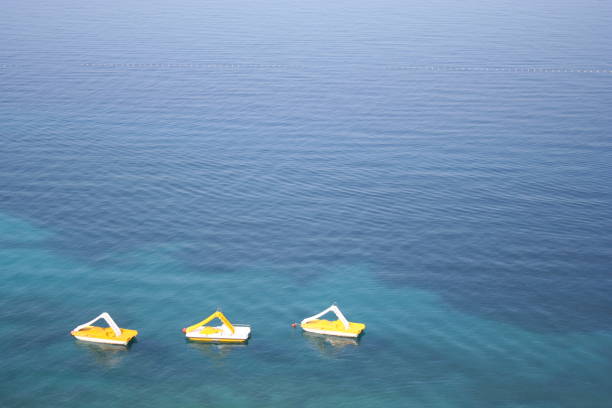 Three yellow pedal boats on the water