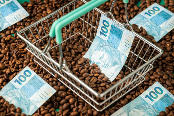 carrinho de compras em miniatura repleto de grãos de café e dinheiro do dinheiro do brasil, o conceito de aumento de preços e rentabilidade do negócio relacionado à produção e venda de café brasileiro - real food fotos - fotografias e filmes do acervo