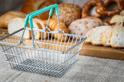 Empty Shopping Cart Around Groceries, Breads and Pastries. The concept of inflation, rising prices and more expensive food
