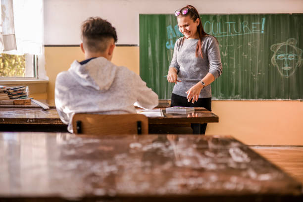 istock Teacher helping her student with an art project 1364074450