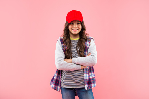 cheerful teen girl hipster in cap on pink background, hipster.