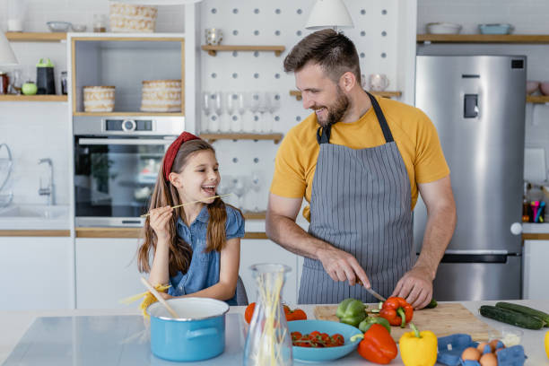 istock Having fun while preparing healthy meal with father in the kitchen 1364074748