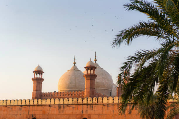 istock Birds flying over mosque in Pakistan at sunset 1364075867