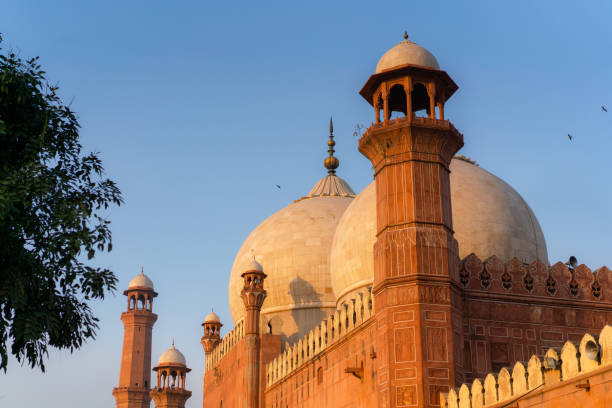 istock Birds flying over mosque in Pakistan at sunset 1364075888