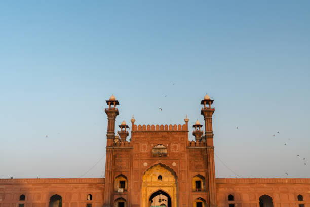 istock Birds flying over mosque in Pakistan at sunset 1364075902