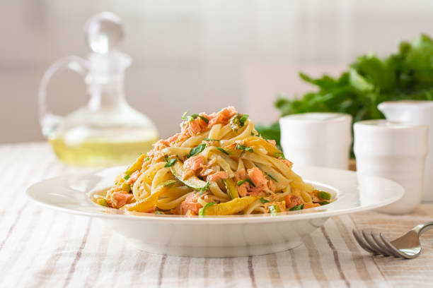 istock Italian dinner. Linguine pasta with salmon and zucchini on a table. 1364077492