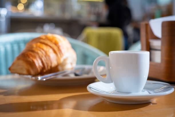 istock Breakfast with a a cup of white coffee and croissant in background 1364078351