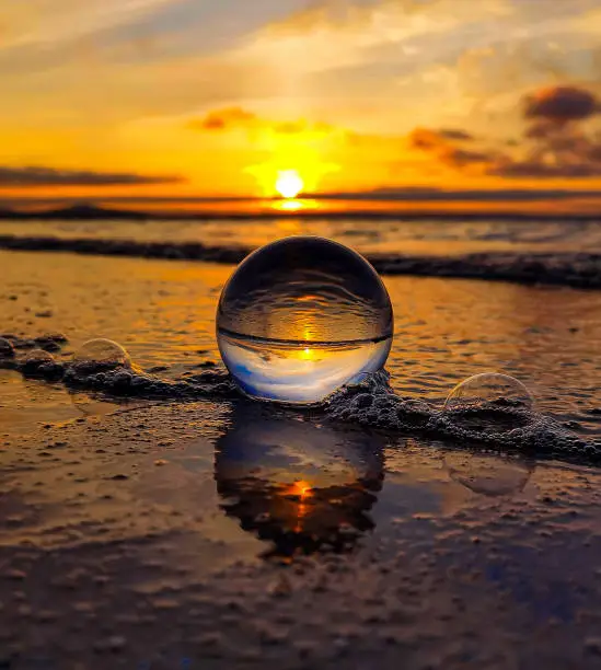 Glassball as the tide comes in during the sunset in Orkney