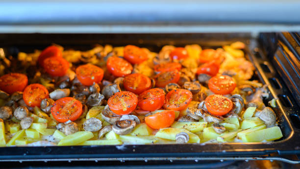 pommes de terre au four avec champignons tomates cerises au four - close up roasted meal pepper photos et images de collection