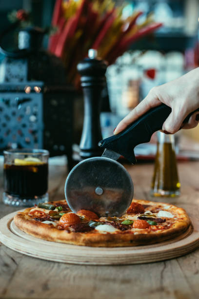 istock slicing freshly baked pizza with round cutter wheel before eating 1364079178