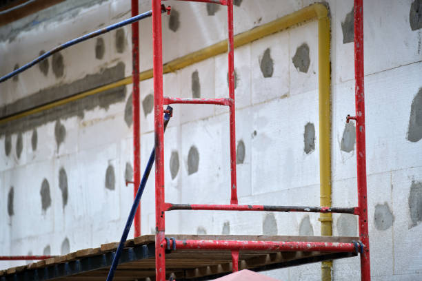 istock Building facade under renovation works with construction scaffolding frame. Wall insulation with styrofoam sheets for energy efficient home 1364083888