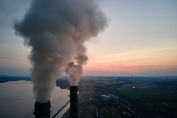 vista aérea de canos altos de usinas de carvão com fumaça preta movendo-se para cima atmosfera poluente ao pôr do sol. produção de energia elétrica com conceito de combustível fóssil - vapor trail night sky sunset - fotografias e filmes do acervo