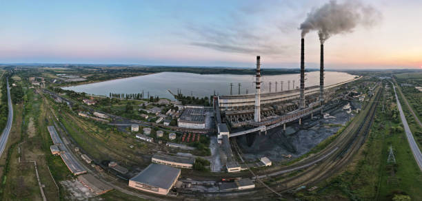 vista aérea de canos altos de usinas de carvão com fumaça preta movendo-se para cima atmosfera poluente ao pôr do sol. produção de energia elétrica com conceito de combustível fóssil - vapor trail night sky sunset - fotografias e filmes do acervo