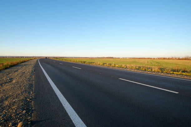 istock Empty intercity road with asphalt surface and white markings in evening 1364083996