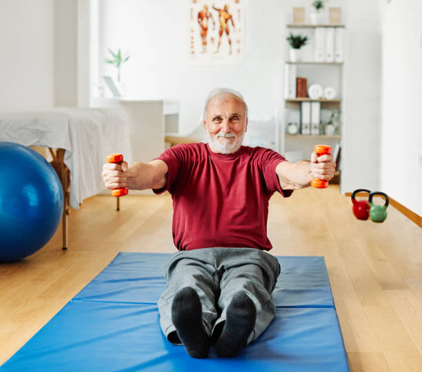istock doctor senior care exercise physical therapy exercising help retirement  physiotherapy strech band clinic therapist elderly man 1364085676