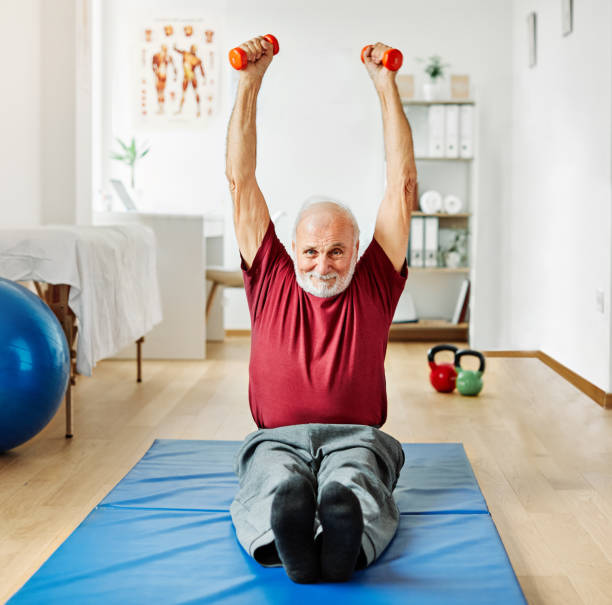 istock doctor senior care exercise physical therapy exercising help retirement  physiotherapy strech band clinic therapist elderly man 1364085830