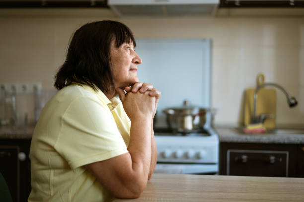 istock An elderly woman sits at table in the kitchen by the window with a pensive view 1364085961