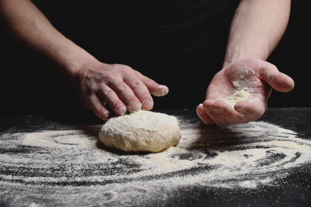 as mãos do baker fazem massa de pão. processo da indústria de alimentos e bebidas. - bread kneading making human hand - fotografias e filmes do acervo