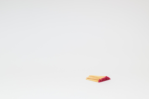 A small stack of matchsticks in the lower right corner on a white background