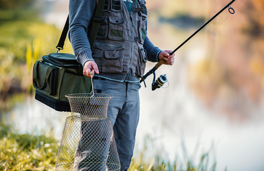 Angling, sport and recreation. Fisherman angling on the river, close up photo