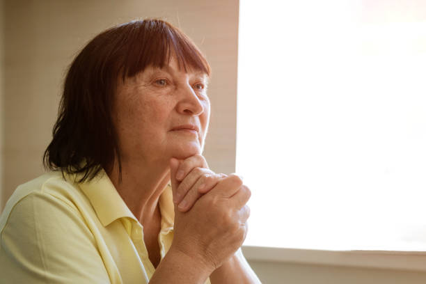 istock An elderly woman sits at table in the kitchen by the window with a pensive view 1364088079