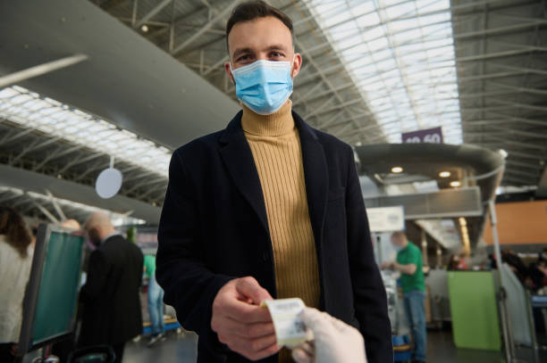istock Handsome young man in a protective medical mask receives a QR code after being tested before departure at the international airport. Safe flight and travel during a pandemic 1364089558