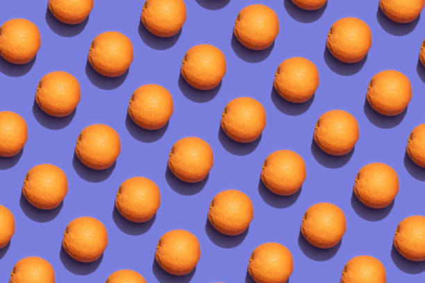 istock Fruit oranges in checkered pattern on violet background. Violet and orange colors background from fruity oranges. Demonstrating very peri, color of 2022 year. 1364090904