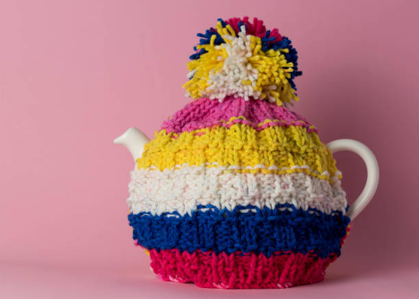 Pot of tea with a hand knitted tea cosy stock photo