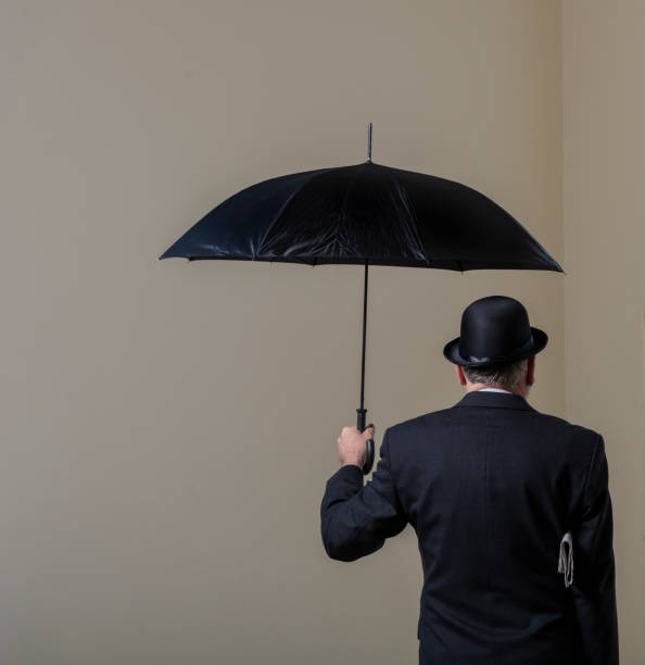 Englishman in bowler hat and open black umbrella. stock photo