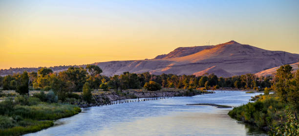 Sunset on the Boise River View of the Boise River and Table Rock Mountain in southeast Boise, Idaho boise river stock pictures, royalty-free photos & images
