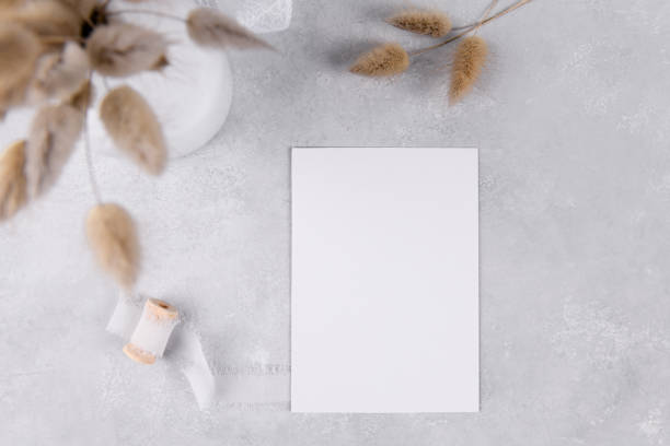 istock blank card mockup, wedding stationery invitation on grey stone table background with white ribbon, 3,5x5 1364094238