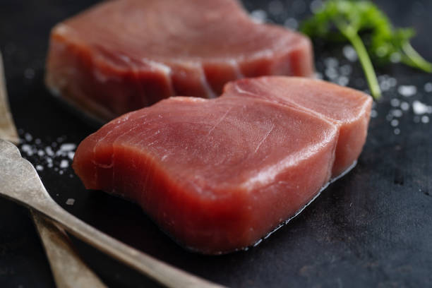 istock Raw tuna steaks on dark background 1364095742