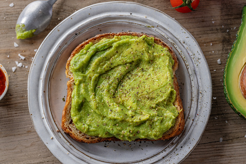 Woman eating fresh salad, avocado, beans and vegetables.