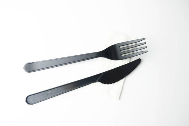 istock Clean plastic black forks and knives on white background. Disposable dishes, environmental pollution. 1364099197