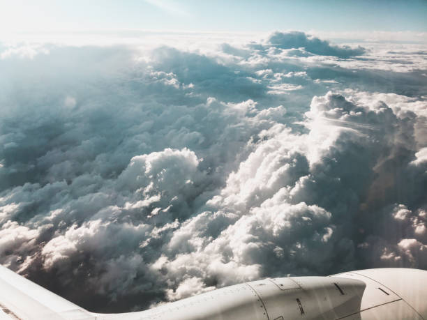 View of sky from above the clouds and airplane engine. Shot from airplane window.