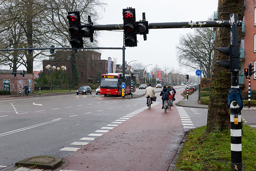 Enschede, Overijssel, Netherlands, december 15th 2021, daytime traffic (bus, cars, bicycles) at the stoplight on the Hengelosestraat at the crossing with Roessinghsbleekweg downtown Enschede - with a population of 160.000 (2021) the Enschede municipality is the 14th largest in the country