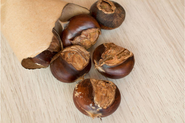 istock Various roasted chestnuts in paper bag on a wooden background 1364106290