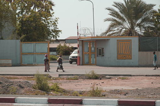 Djibouti, Djibouti - May 21 2021: 2 Djiboutian women and Djiboutian little girl in local dress walking on the road. A man walking on the road. Editorial shot in Djibouti.