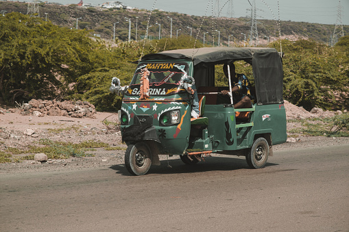 Djibouti, Djibouti - May 21, 2021: Auto rickshaw local taxi on the road in Djibouti. Editorial shot in Djibouti.