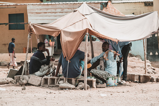 Djibouti, Djibouti - May 21, 2021: The Djiboutian people sitting and chatting all together under a tent in Djibouti. A Djiboutian man gets angry at a photographer for taking a photo. Editorial shot in Djibouti.