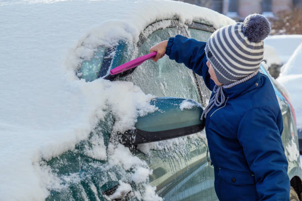 istock Little boy clean snow  off from car 1364107311