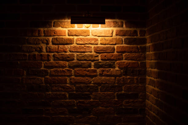 istock Brick wall illuminated by warm light from a lamp 1364108188