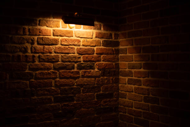 istock Brick wall illuminated by warm light from a lamp 1364108189