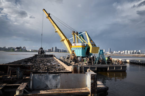 funktionierender baggerkran in küstennähe - industrial ship earth mover barge yellow stock-fotos und bilder