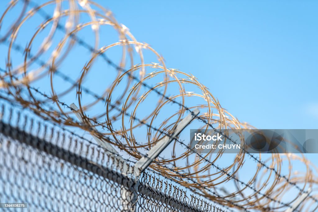 Barbed wire Dangerous barbed wire fence keeping unwanted intruders away. Razor Wire Stock Photo