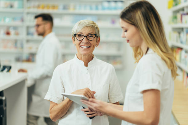 istock Senior female pharmacist using a tablet while working in a pharmacy with her young colleague 1364110876