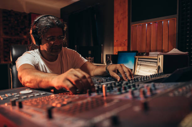 istock Senior hispanic music producer working on a mixing soundboard while in his studio 1364110898