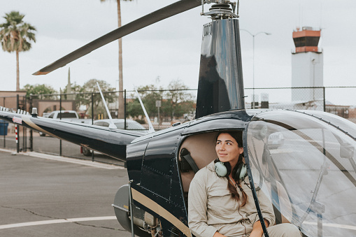 Female helicopter pilot flying off runway